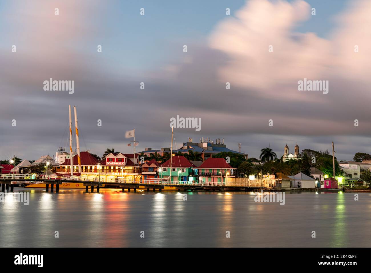 Farbenfrohe Gebäude des Einkaufsviertels Heritage Quay spiegeln sich in der Abenddämmerung im Meer wider, St. John's, Antigua, Karibik, westindien Stockfoto