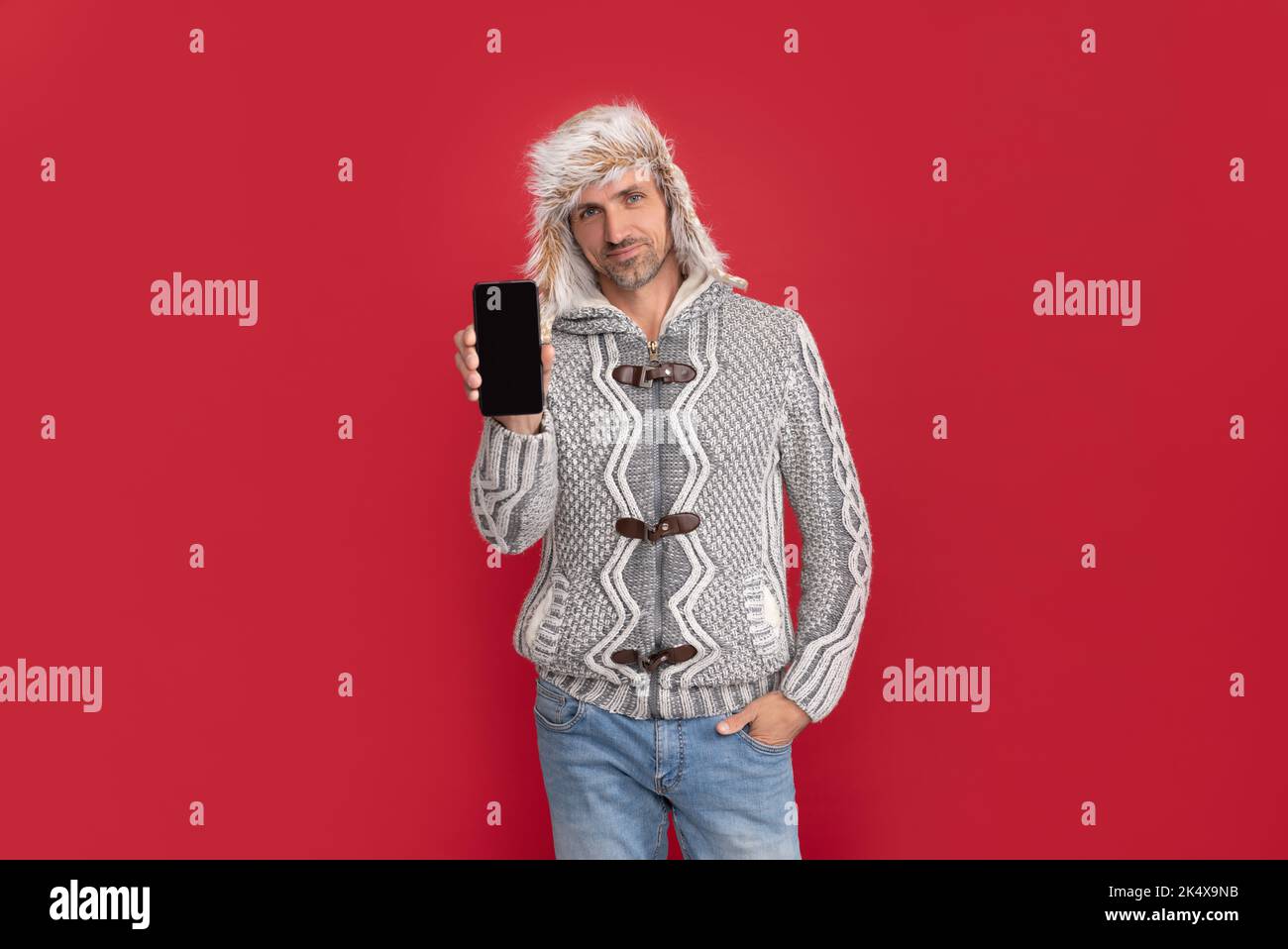 Hoary Mann zeigen Telefon. Männlich Mode Modell halten Smartphone. Stockfoto