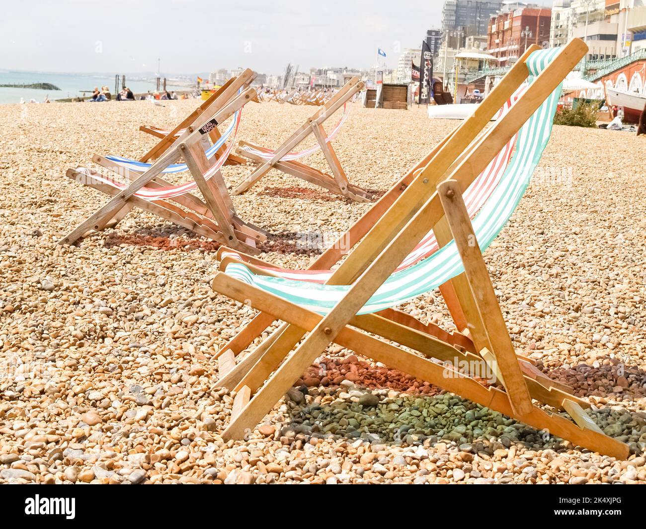 Klappstühle in rot und grün mit weißen Streifen am Brighton Beach gestreift. Stockfoto