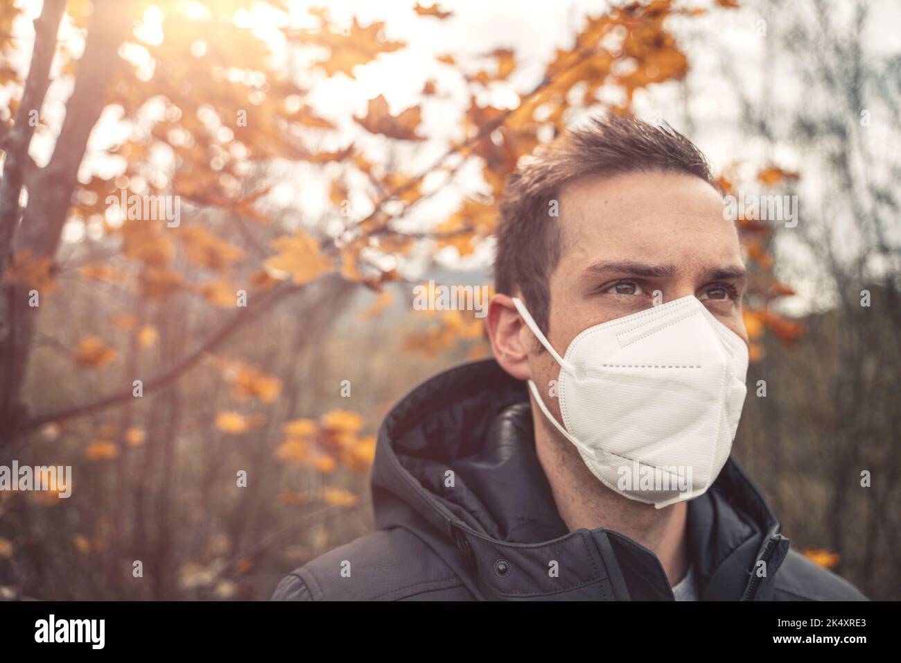 03. Oktober 2022: Junger Mann trägt FFP 2 Maske während des Herbstspaziergangs im Freien, um sich vor dem Coronavirus zu schützen, Covid 19. Symbolbild Corona Herbst Und Stockfoto