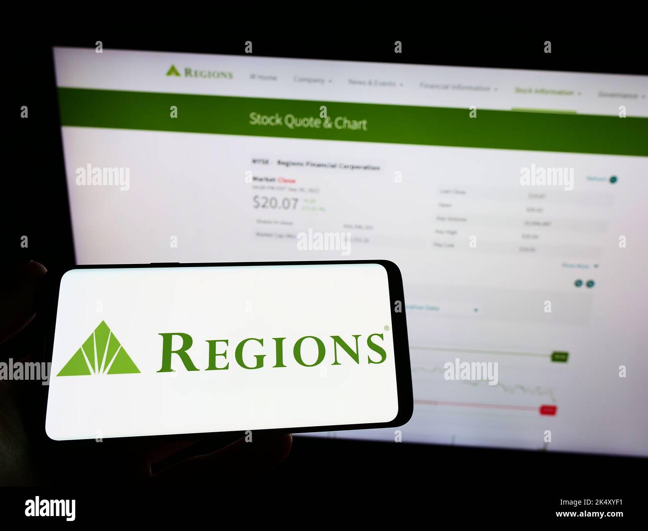 Person, die ein Mobiltelefon mit dem Logo des US-amerikanischen Bankunternehmens Regions Financial Corporation auf dem Bildschirm vor der Webseite hält. Konzentrieren Sie sich auf die Telefonanzeige. Stockfoto Person, die ein Mobiltelefon mit dem Logo des US-amerikanischen Bankunternehmens Regions Financial Corporation auf dem Bildschirm vor der Webseite hält. Konzentrieren Sie sich auf die Telefonanzeige. Stockfoto