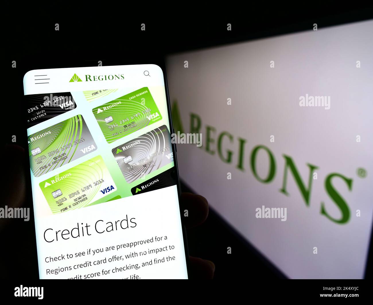 Person mit Mobiltelefon und Webseite des US-Bankunternehmens Regions Financial Corporation auf dem Bildschirm mit Logo. Konzentrieren Sie sich auf die Mitte des Telefondisplays. Stockfoto Person mit Mobiltelefon und Webseite des US-Bankunternehmens Regions Financial Corporation auf dem Bildschirm mit Logo. Konzentrieren Sie sich auf die Mitte des Telefondisplays. Stockfoto