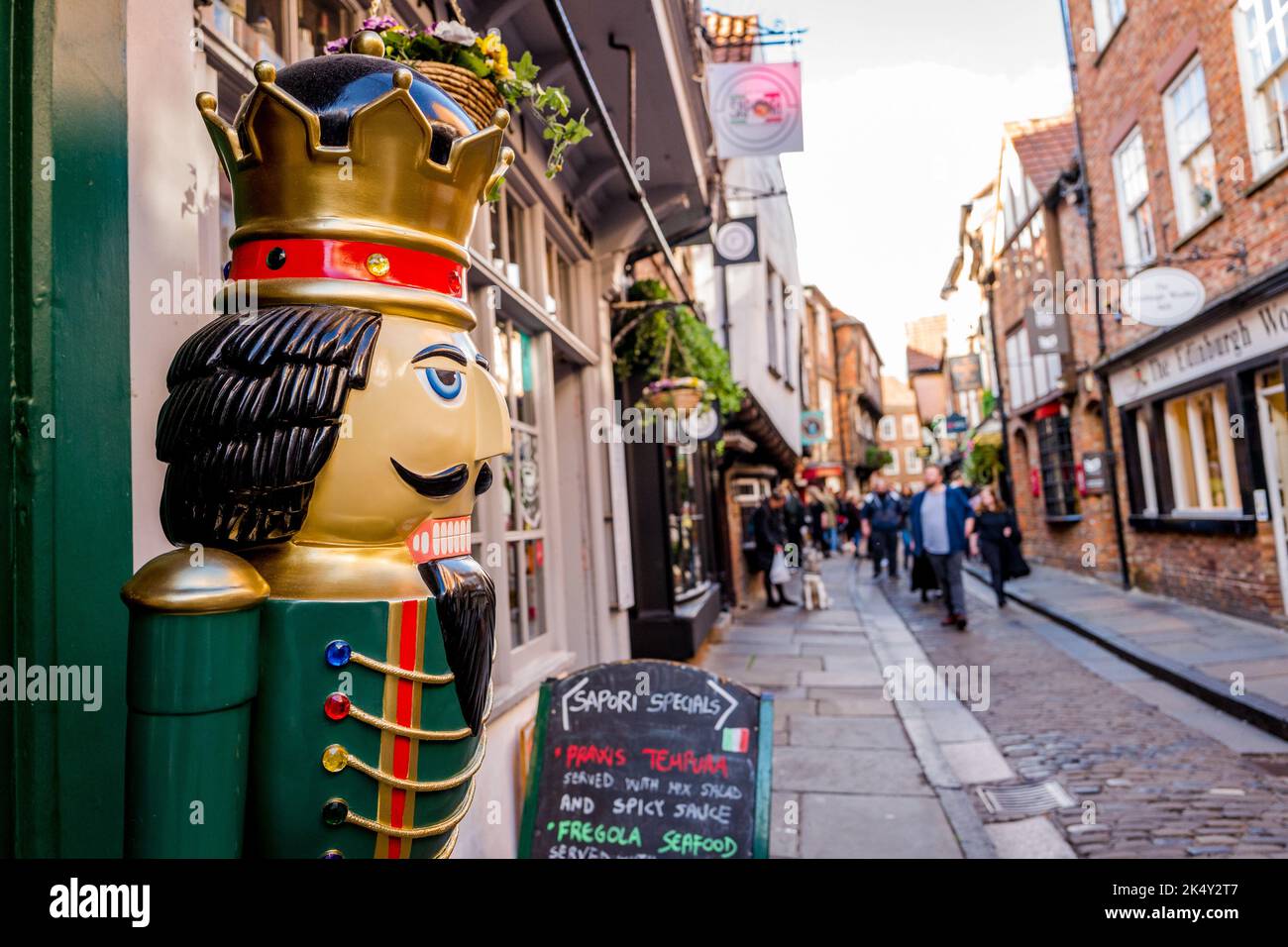 Zwei lebensgroße Ladenhüter stehen vor dem Nussknacker-Weihnachtsgeschäft entlang der berühmten Shambles Street in York. Stockfoto