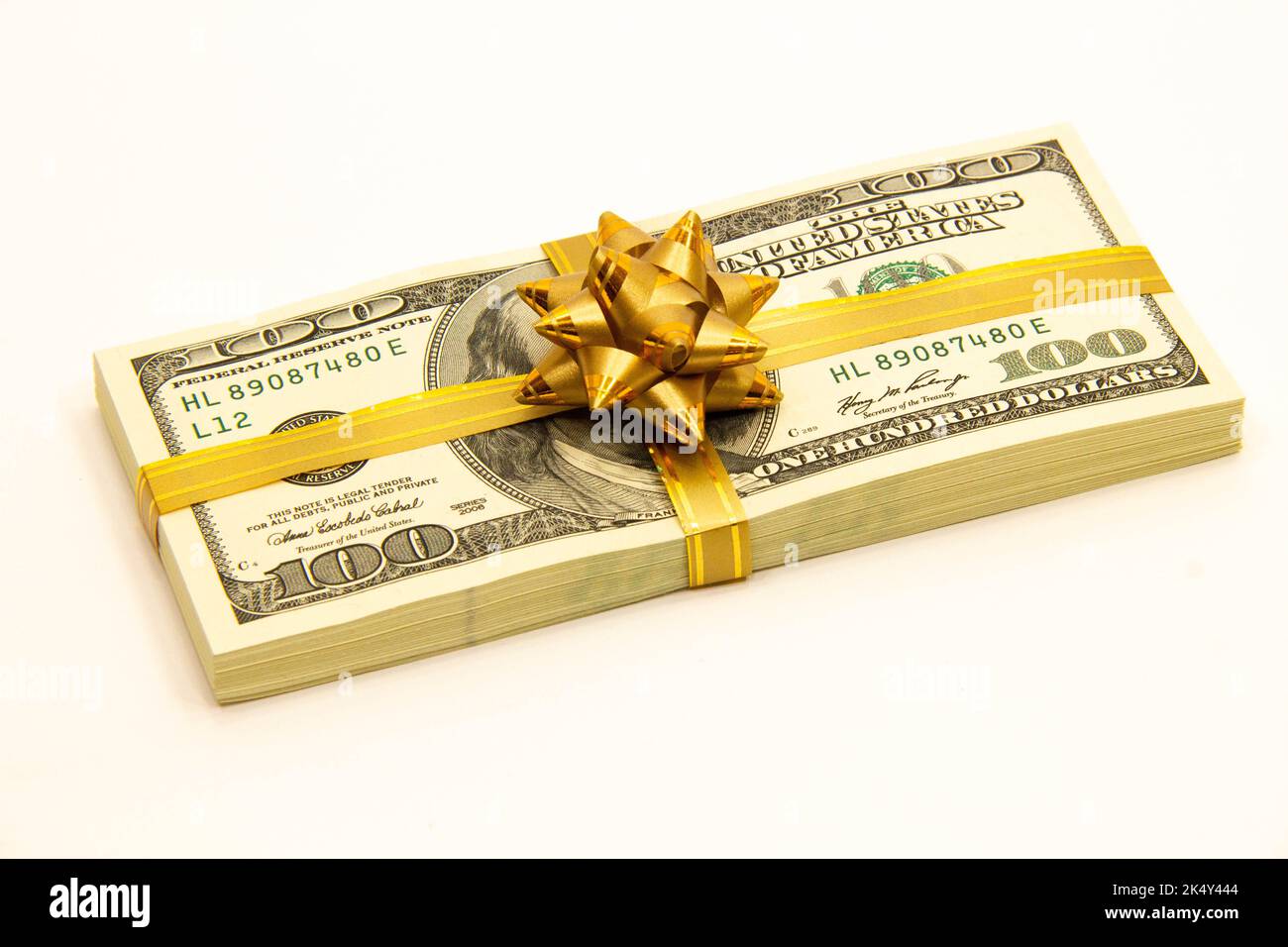 Dollarpaket mit Geschenkschleife. Dollarstapel. US-Dollar-Banknoten. Ein Stapel amerikanischer 100-Dollar-Scheine. Konzept des Bankgeschäfts Stockfoto