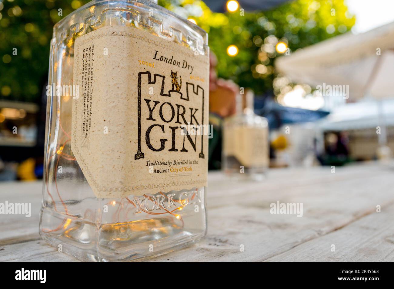 Leere Glasflasche mit London Dry york Gin, die als Tischbeleuchtung in einem Restaurant im Freien, York, Yorkshire, England, verwendet wurde. Stockfoto