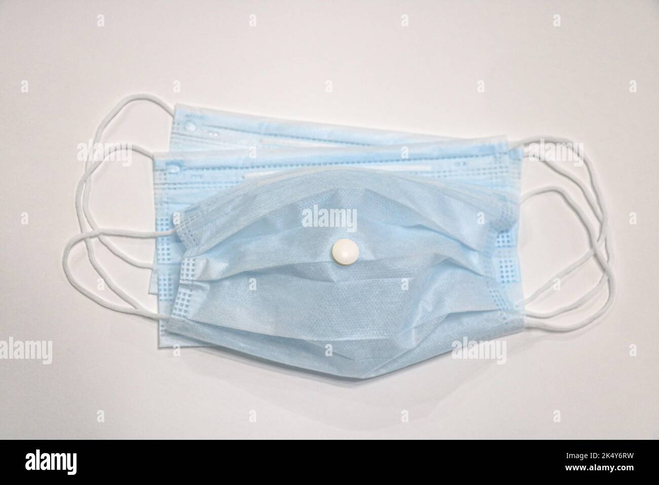 Eine Nahaufnahme einer chirurgischen Gesichtsmaske und Pillen Stockfoto