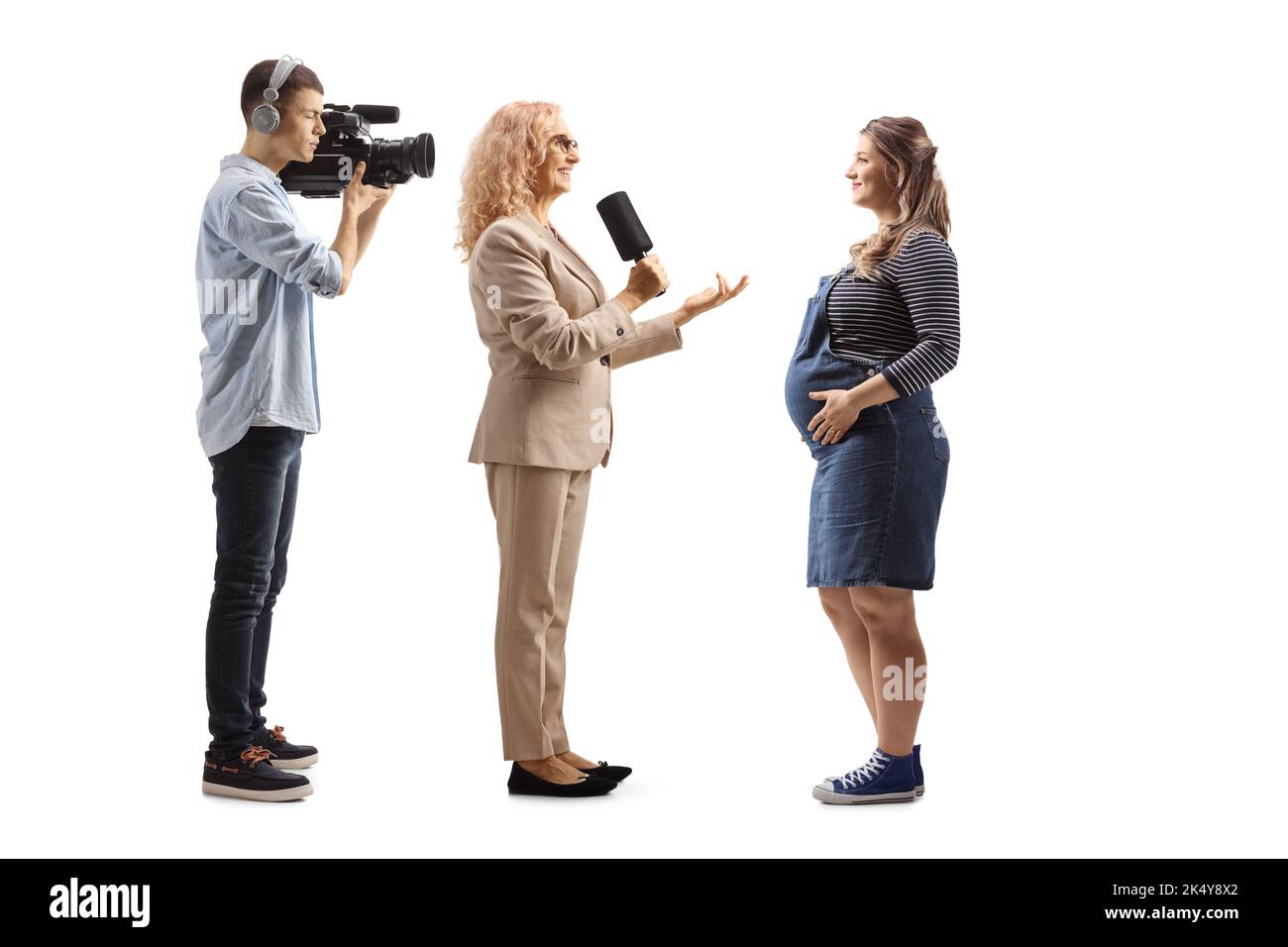 Eine Reporterin interviewte eine Schwangere und einen Kameramann, der auf weißem Hintergrund auftagebend war Stockfoto
