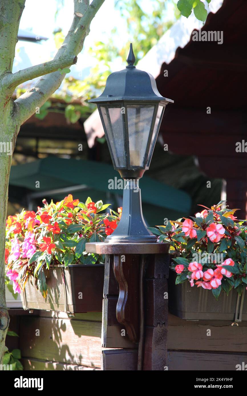 Kleine Gartenlaterne mit Blumen auf dem Balkon Stockfoto