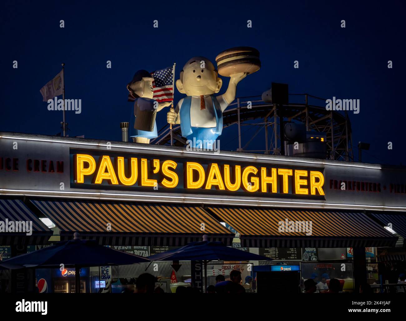 New York, NY - USA - 3. September 2022 Nachtansicht des Neonzeichens von Pauls Tochter mit ihren ikonischen Dachstatuen einer Familie, die hamb schwingt Stockfoto