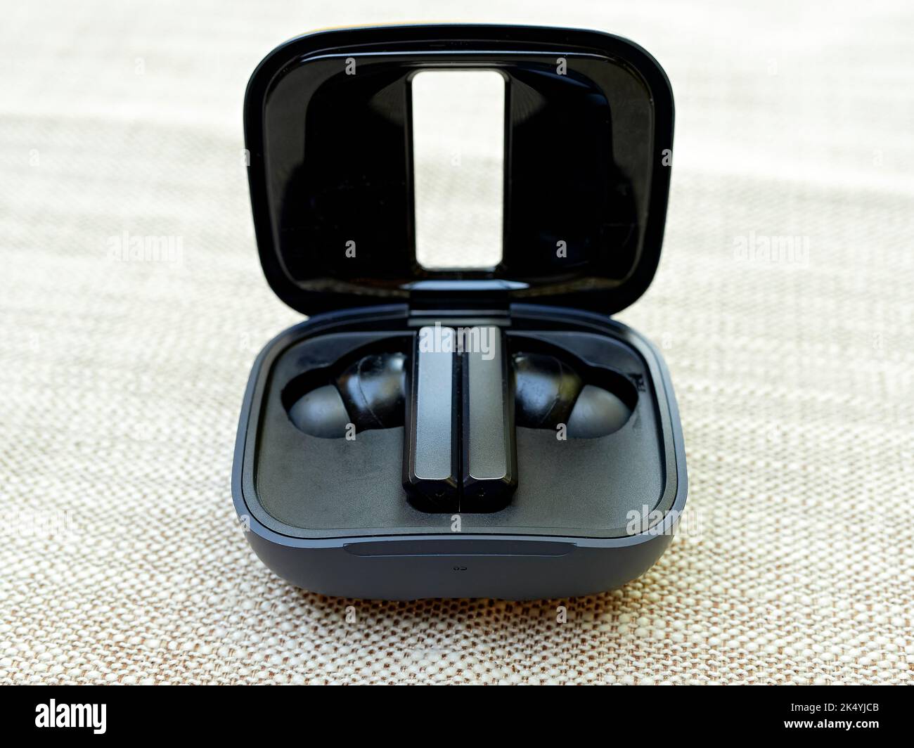 Schwarze Ohrstöpsel, die zum privaten Hören von Musik, Videos oder Podcasts in einem offenen Ohrstöpsel verwendet werden. Stockfoto