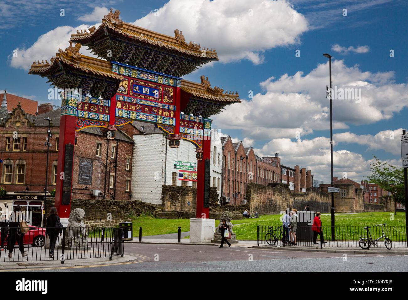 Newcastle-upon-Tyne, England, Vereinigtes Königreich.  Chinatown Eingangsbogen, St. Andrews Street.  Reste des 13. Jahrhundert Stadtmauer in mittlerer Entfernung. Stockfoto