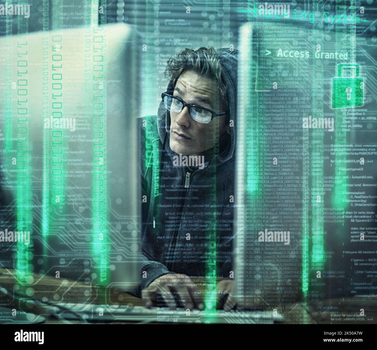 Hacking der Hauptrahmen. Ein junger Mann trägt Hoodie, während Hacking in einen Computer. Stockfoto
