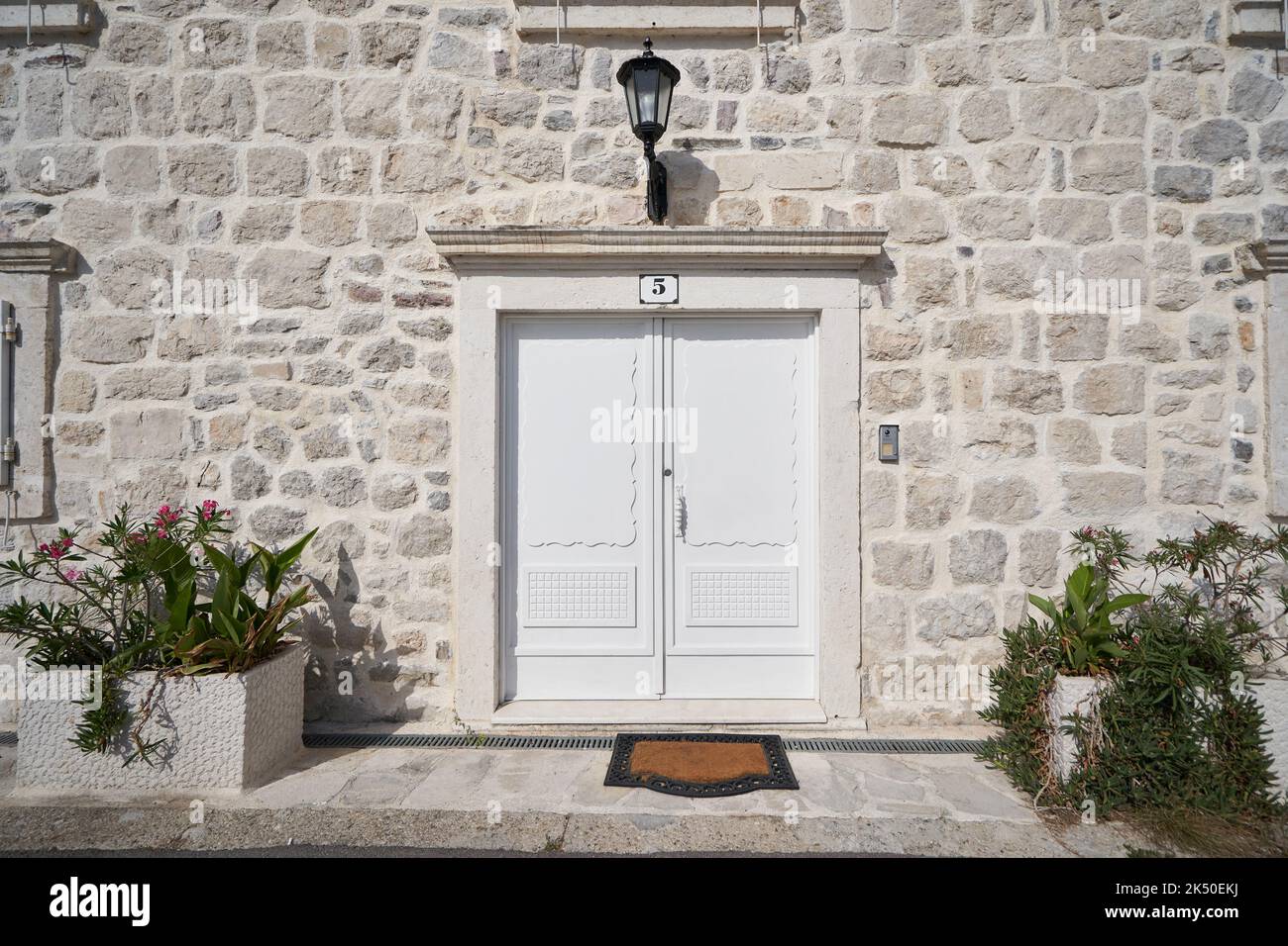 Weiße Eingangstür zu einem alten Steinhaus. Stockfoto