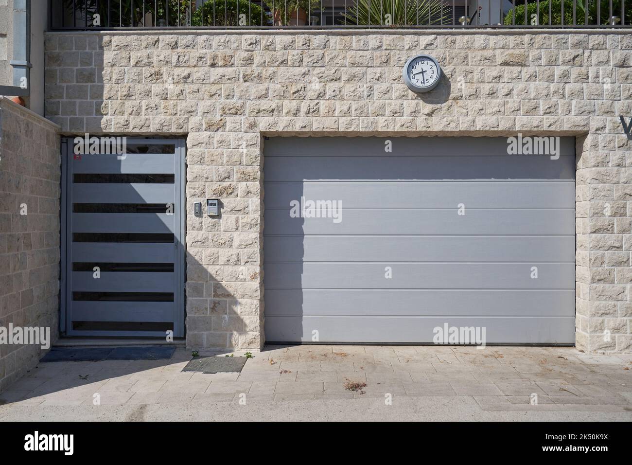 Garagenfassade mit Eingangstür und Garagentor grau. Stockfoto