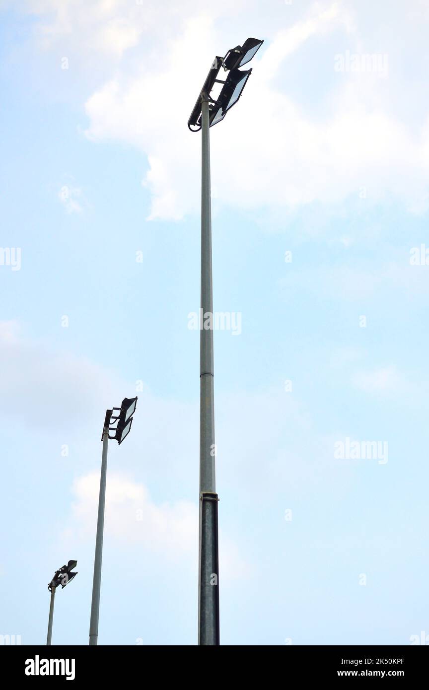 Hohe Stehhöhe oder Leuchttürme im Sportstadion aus niedrigem Winkel bei strahlendem Sonnenschein oder tagsüber. Stockfoto