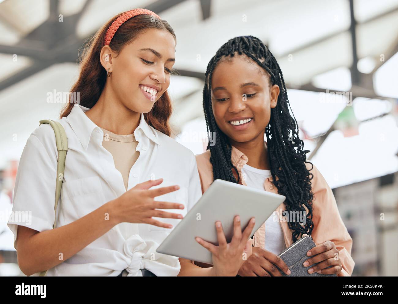 Studenten, Freundinnen und Tablets forschen am Lernen, Studieren und an der Uni. Fröhliche Vielfalt Jugendliche lesen digitale Akademiker Stockfoto