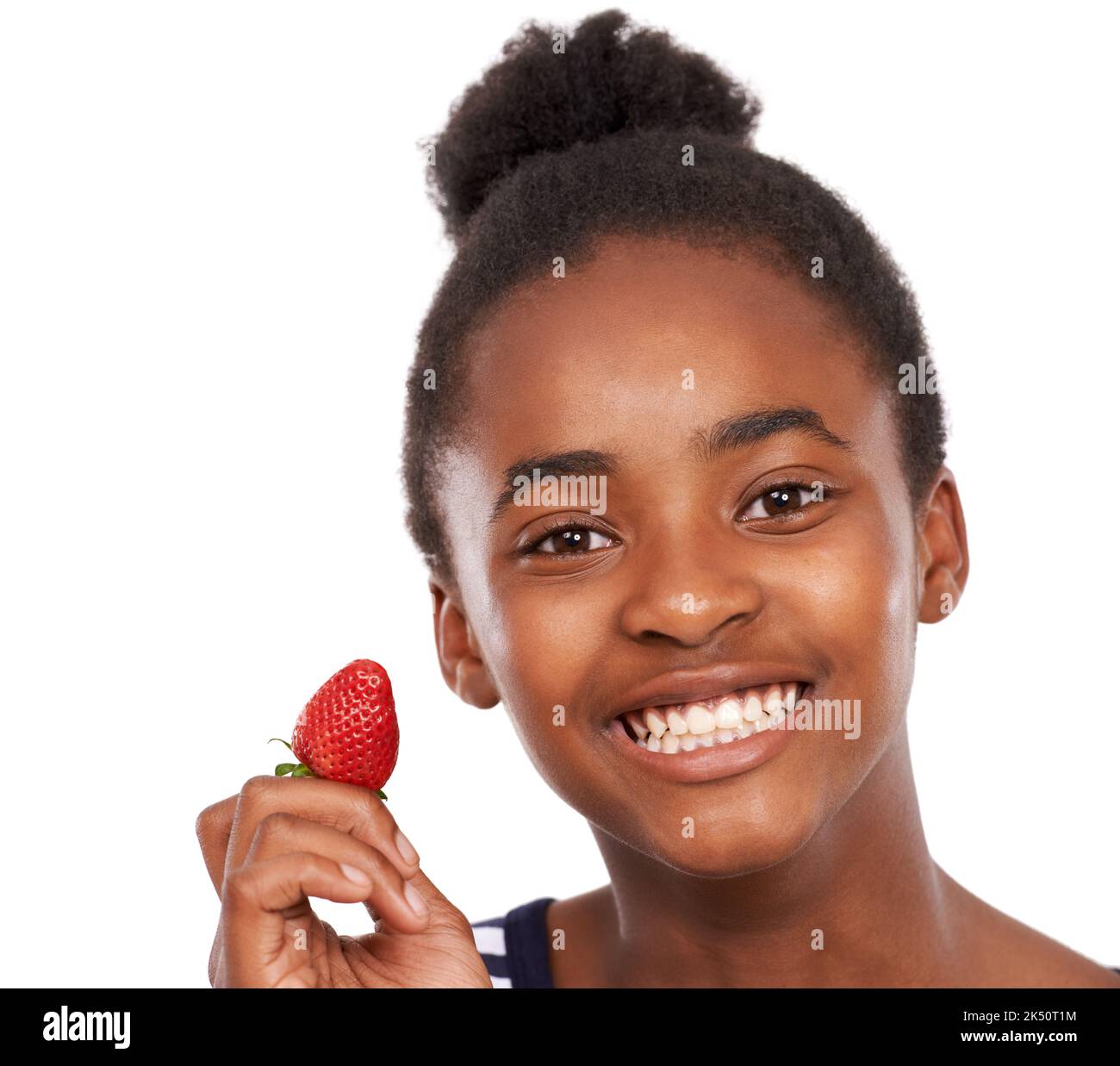 Nur noch eine Erdbeere. Studioportrait eines glücklichen jungen afroamerikanischen Mädchens, das eine auf Weiß isolierte Erdbeere hält. Stockfoto