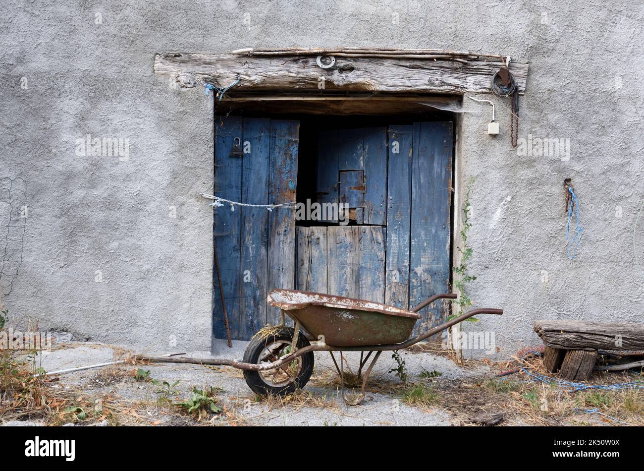 Old Barn Door und Rusty Wheelbarrow Stockfoto