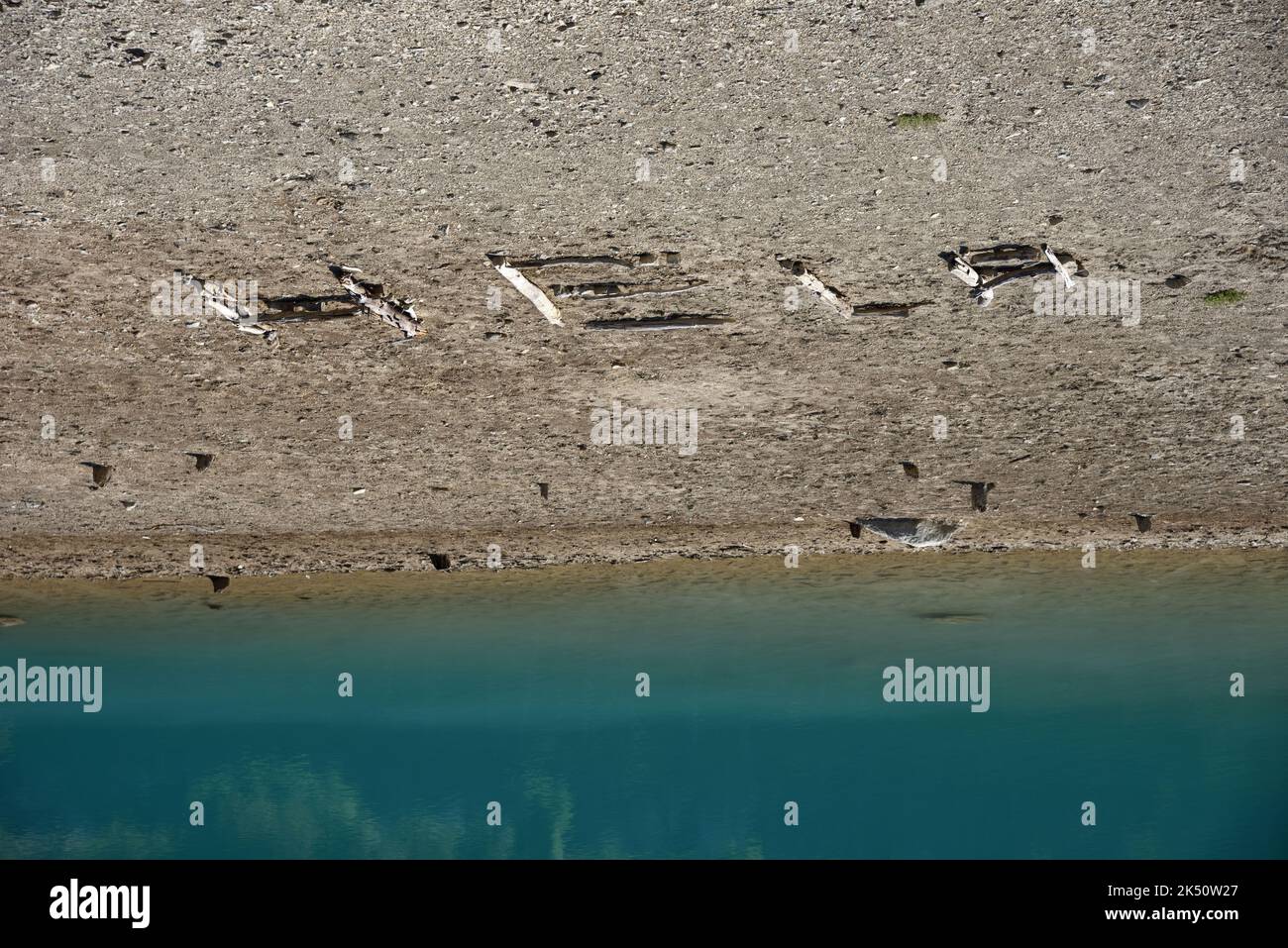 Hilfe geschrieben in Schlamm am See von Shrinking Lake aufgrund von Klimawandel, Umweltkrise, Dürre und extremem Wetter; Rette unseren Planeten. Stockfoto