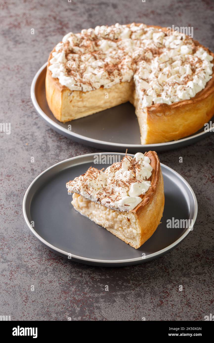 Rijstevlaai Dutch Reispudding-Torte mit Schlagsahne und Schokoladenchips in Nahaufnahme auf einem Teller auf dem Tisch abstücken. Vertikal Stockfoto
