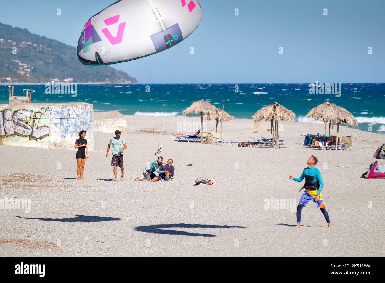 Kitesurfer versuchen, den Drachen vor dem starken Wind zu halten. Strand von Agiokampos, griechenland Stockfoto