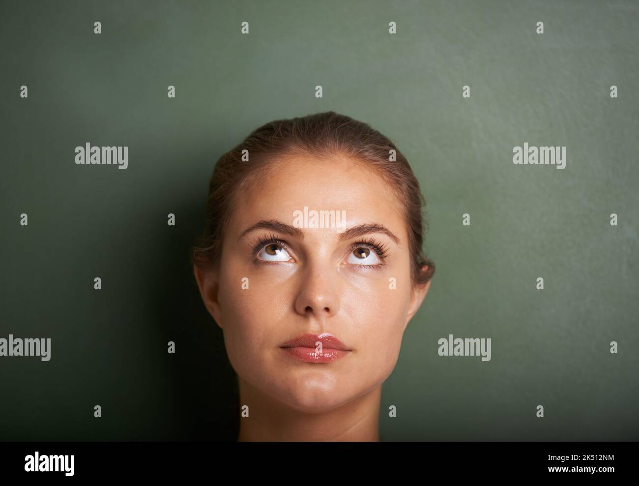 Ein paar Ideen...Nahaufnahme einer jungen Frau, die vor einer Tafel steht und nach oben schaut. Stockfoto