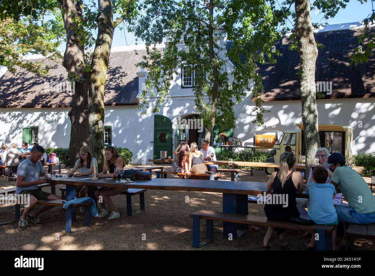 Besucher trinken an Tischen im Freien im Boschendal Wine Estate in Western Cape, Südafrika Stockfoto