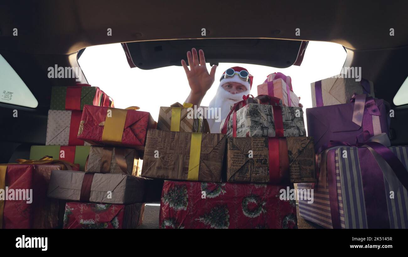 weihnachtsmann liefert Geschenke. Geschenke vom weihnachtsmann. Lieferservice. Deliveryman lädt Boxen. Geschenk-Boxen im Auto. Schön verpackte Pakete. Blick aus dem Inneren des Autos. Spende, Wohltätigkeit oder Lieferkonzept. Hochwertige Fotos Stockfoto