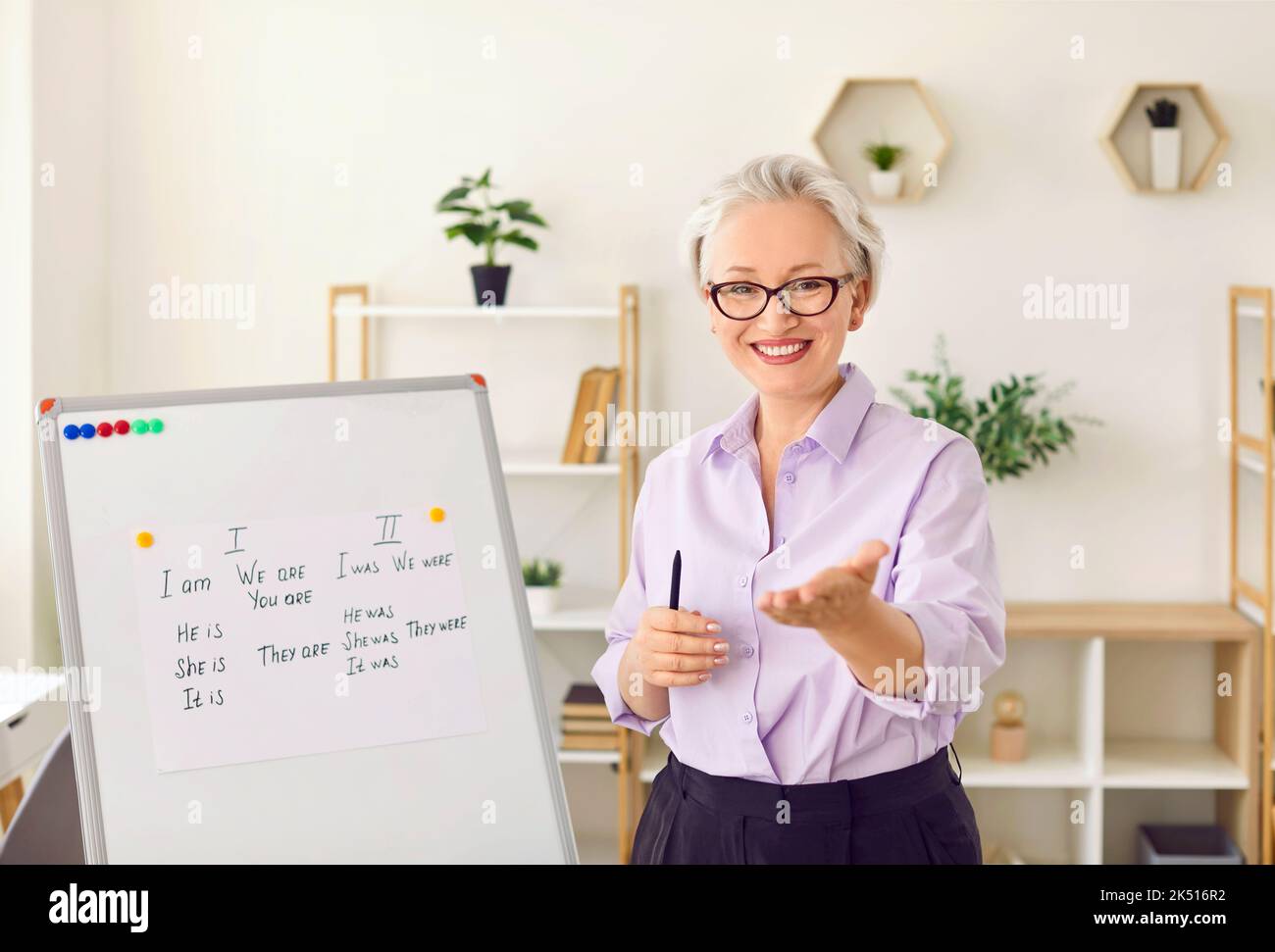 Portrait einer freundlichen älteren Lehrerin, die während des Fernunterrichts die Regeln der englischen Grammatik erklärt Stockfoto