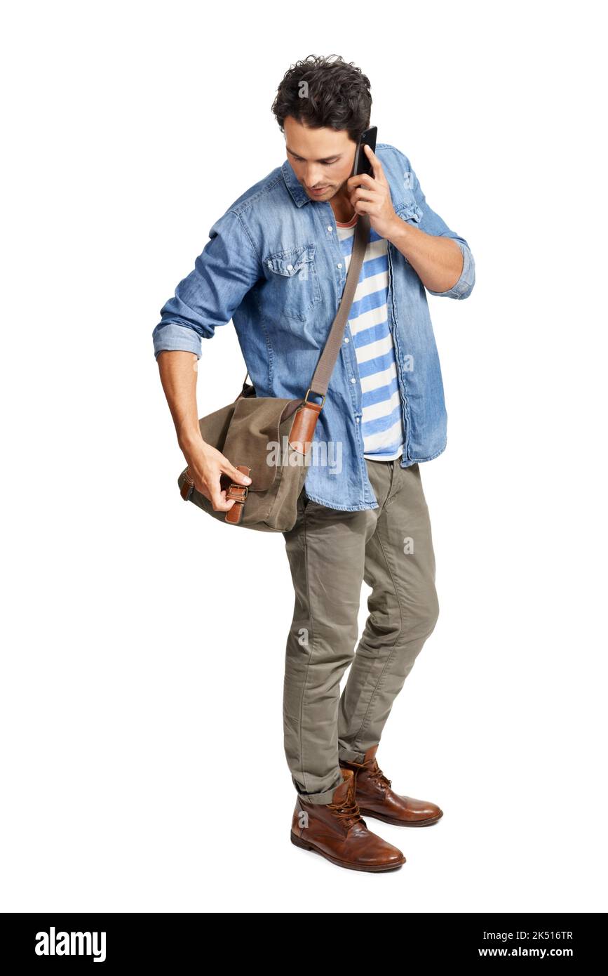 Vorbereitung auf das College. Ein hübscher junger Mann, der etwas in seiner Tragetasche sucht, während er am Telefon spricht. Stockfoto