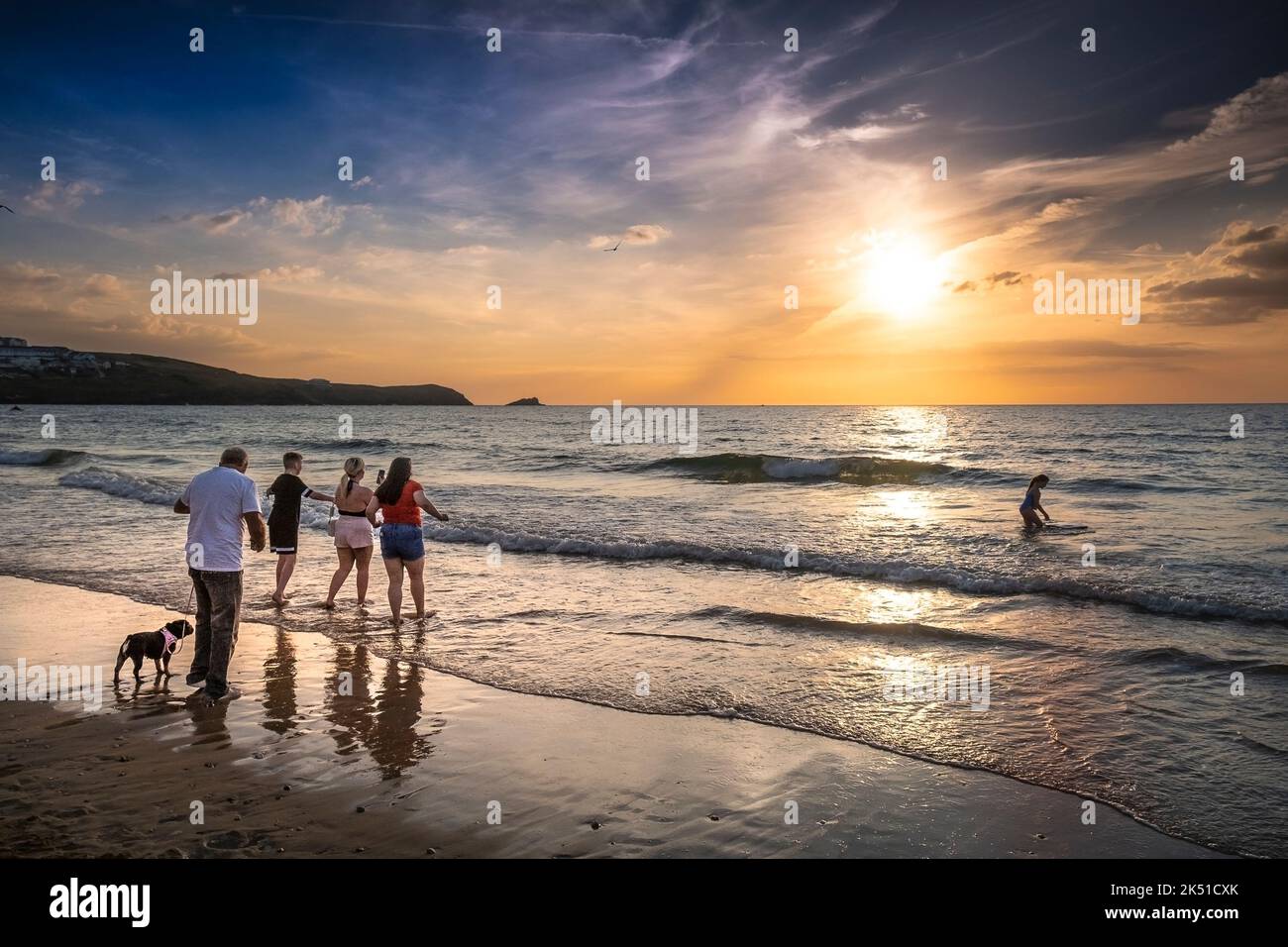 Urlauber genießen einen spektakulären Sonnenuntergang über der Fistral Bay in Newquay in Cornwall in Großbritannien in Europa. Stockfoto