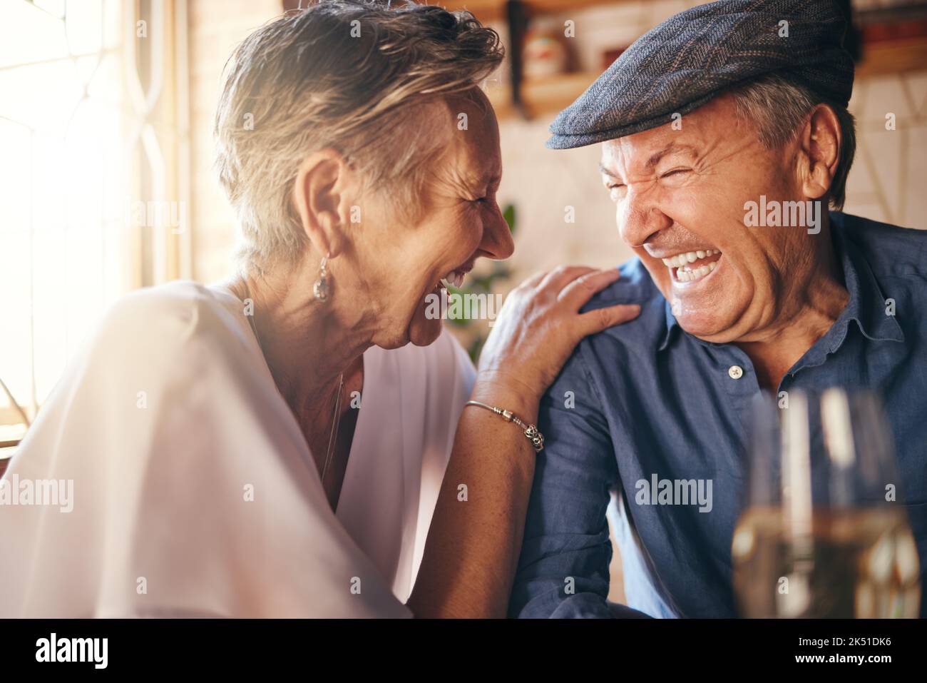 Senior, Paar und Lachen nach Comic Witz zusammen im Restaurant für die Bonding-Zeit. Lächeln, Mann und Frau im Ruhestand lachen über lustige Unterhaltung Stockfoto