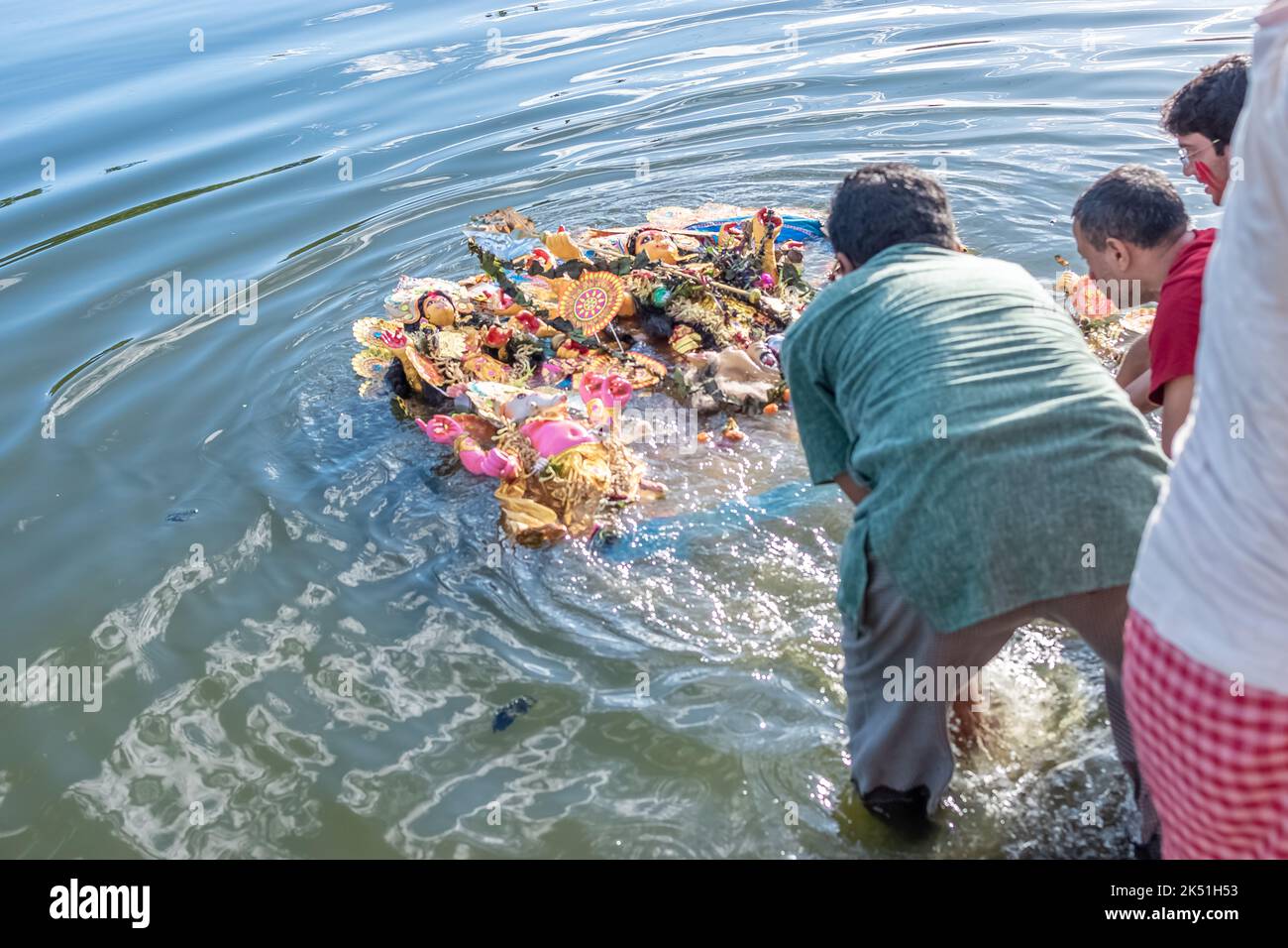 Anhänger tauchen Durga Idol auf dem Fluss Ganges während des letzten Tages des Durga Puja Festivals ein. Stockfoto