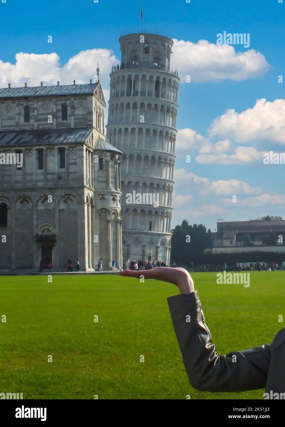 Der schiefe Turm von Pisa an der Hand einer Frau auf der Piazza dei Miracoli, Toskana, Italien. Selektiver Fokus und Rauschen inklusive. Italien - Juli 18 2013. Stockfoto