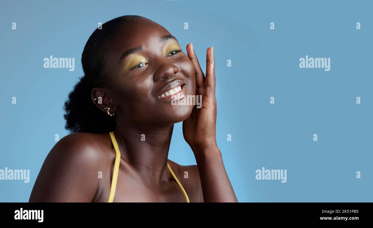 Gelbes Make-up und schwarze Frau Gesicht Schönheit für Hautpflege Kosmetik-Produkt mit blauen Studio-Wand. Denkendes, nachdenkliches und nachdenkliches afrikanisches Mädchen Stockfoto