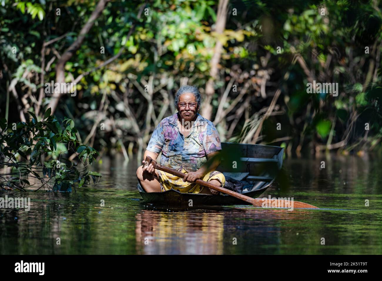 Eine einheimische Frau, die auf einem Dugout-Kanu im Wald von Várzea angeln. Amazonas, Brasilien. Stockfoto