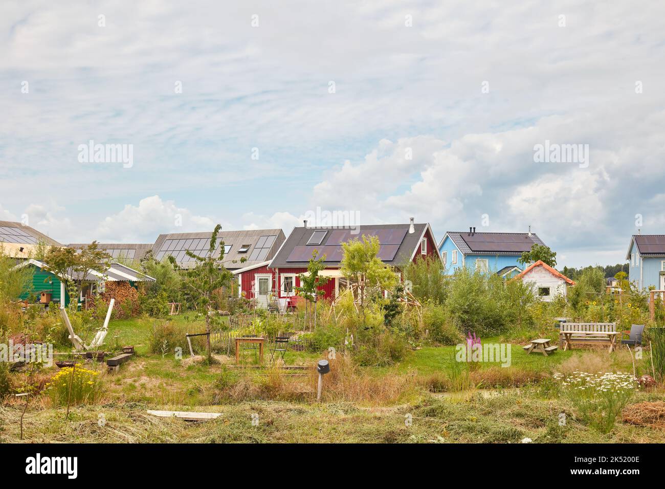 Almere, Niederlande - 14. Juli 2022: Neue kleine Häuser auf Holzbasis mit Gemeinschaftsgarten in der Stadt Almere, Niederlande Stockfoto