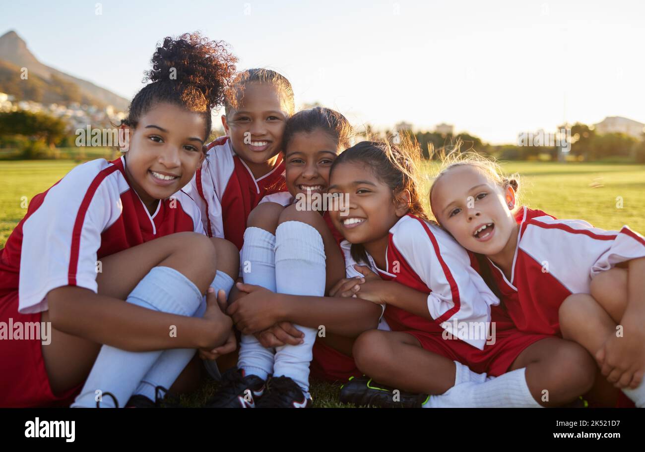 Team, Fußball oder fröhliches Sportmädchen mit Lächeln auf dem Feld, Gras oder Stadion für Gesundheit, Teamarbeit oder Wellness-Porträt. Kinder, Fußball oder trainieren mit Stockfoto