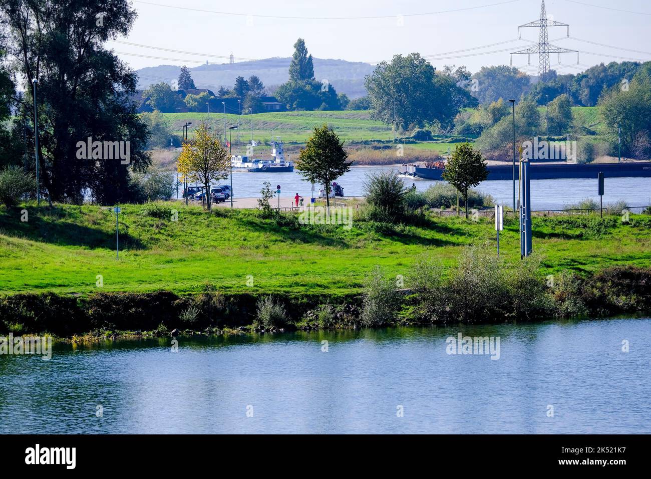 04.10.2022, Duisburg, Nordrhein-Westfalen, Deutschland - Blick über den Rhein und einen Seitenarm auf die Faehre für Personen und Autos, die auf dem Stockfoto