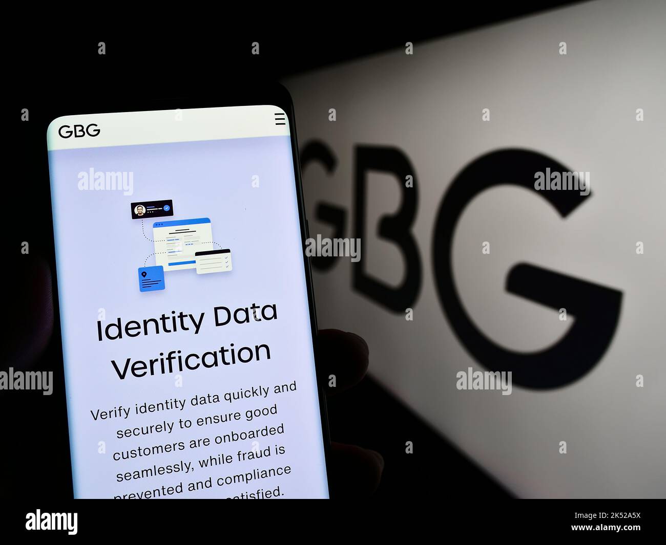 Smartphone mit Webseite der Firma GB Group plc (GBG) zur Identitätsüberprüfung auf dem Bildschirm vor dem Logo. Konzentrieren Sie sich auf die Mitte des Telefondisplays. Stockfoto