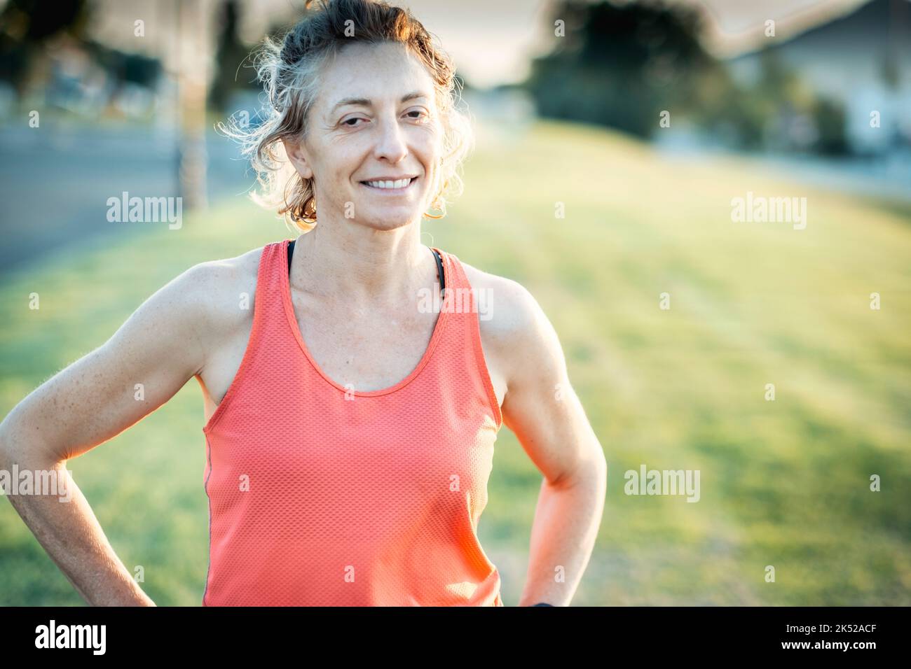Echte junge reife kaukasische Frau in einer Sportkleidung im Park an einem sonnigen Nachmittag. Stockfoto