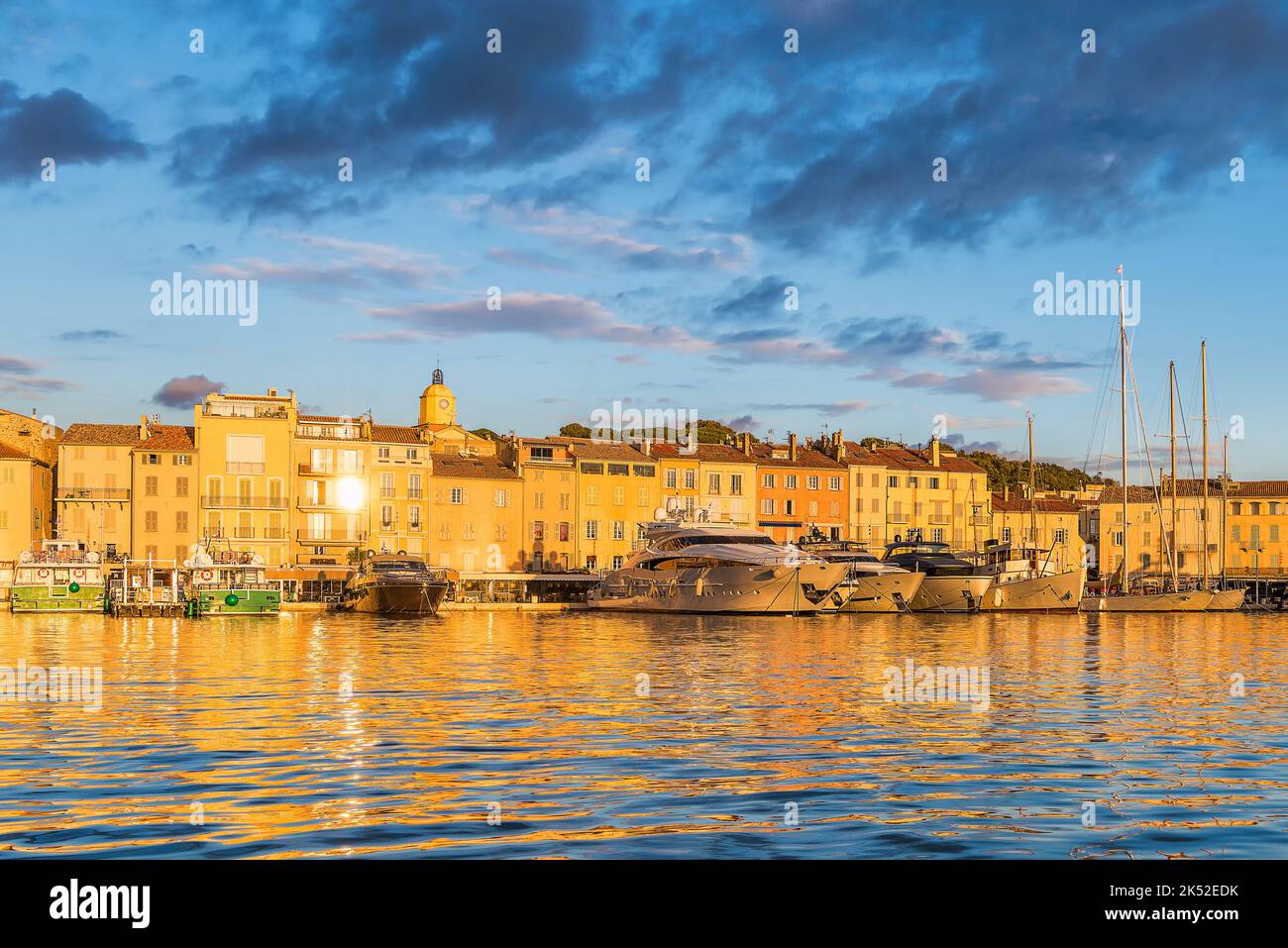 Landschaftlich schöner Blick auf Saint-Tropez im goldenen Abendlicht vor dramatischem Himmel Stockfoto