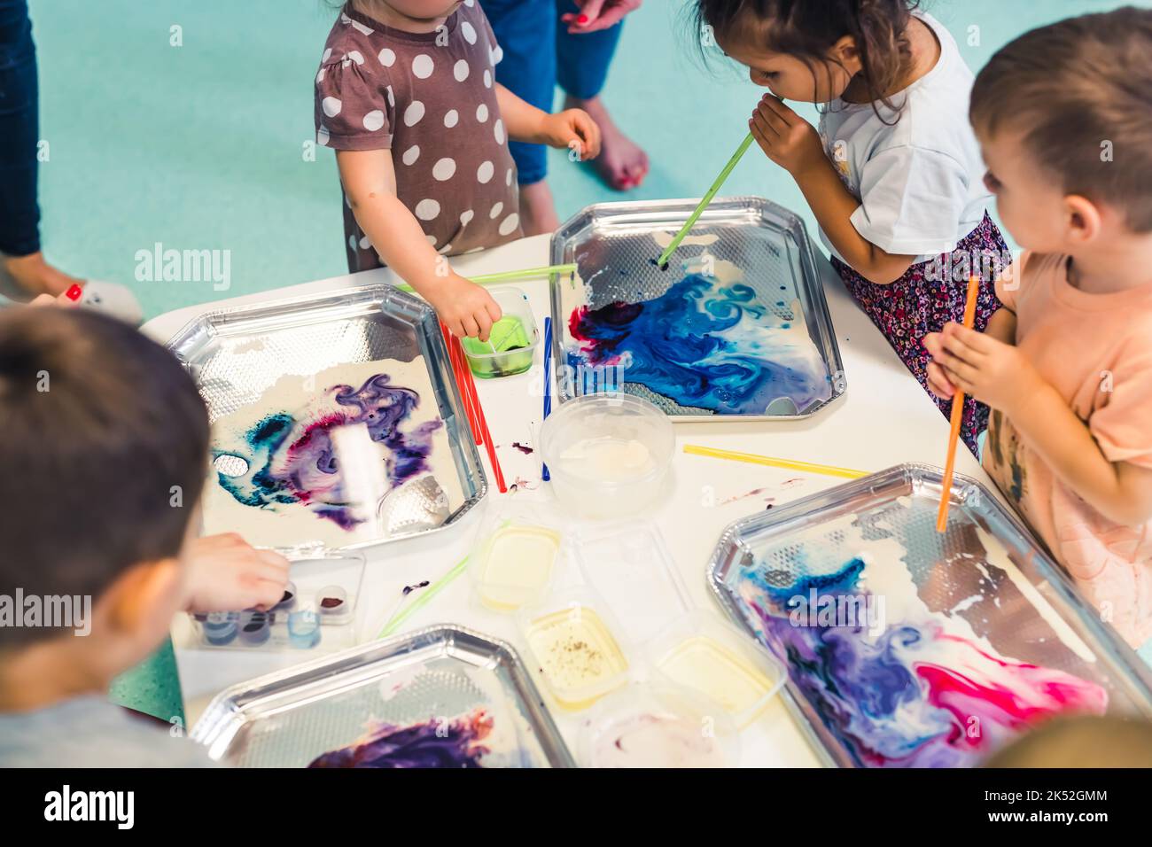 Kinder malen mit kleinen Tuben und Wasserfarben im Kindergarten, moderne Maltechniken. Hochwertige Fotos Stockfoto