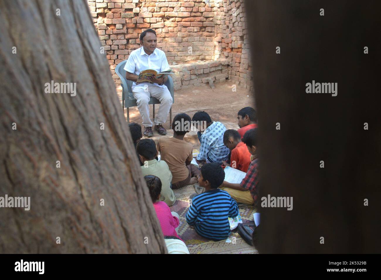 Lahore, Punjab, Pakistan. 5. Oktober 2022. Pakistanische Lehrer der United Social Welfare Society unterrichten ihre Klasse (Dissable Students Class) eine von der Regierung finanzierte Non-formal Basic Education School (NFBES) am Vorabend des Weltlehrertages an einem Ziegelofen in den Außenbezirken von Lahore. Anlässlich des Weltlehrertages, der seit 1994 jährlich am 5. Oktober stattfindet und an Lehrerorganisationen weltweit erinnert. Ziel ist es, die Unterstützung der Lehrer zu mobilisieren und sicherzustellen, dass die Bedürfnisse zukünftiger Generationen weiterhin von den Lehrern erfüllt werden. (Bild: © Rana Sajid Hussain/Pazifik Stockfoto