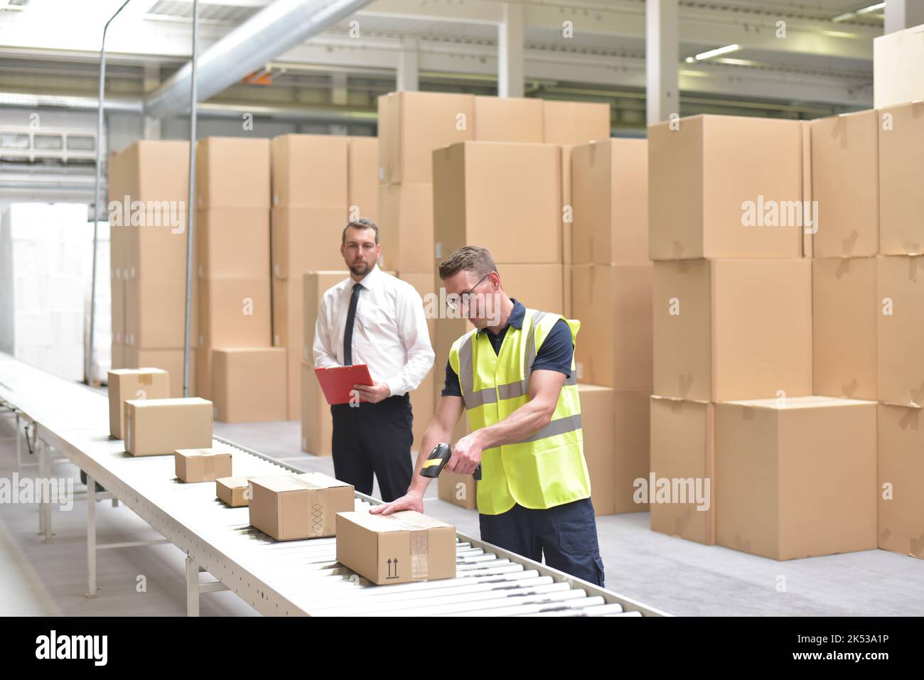 Manager und Arbeiter in einem Lager in der Logistik-Branche - Transport und Bearbeitung von Aufträgen im Handel Stockfoto