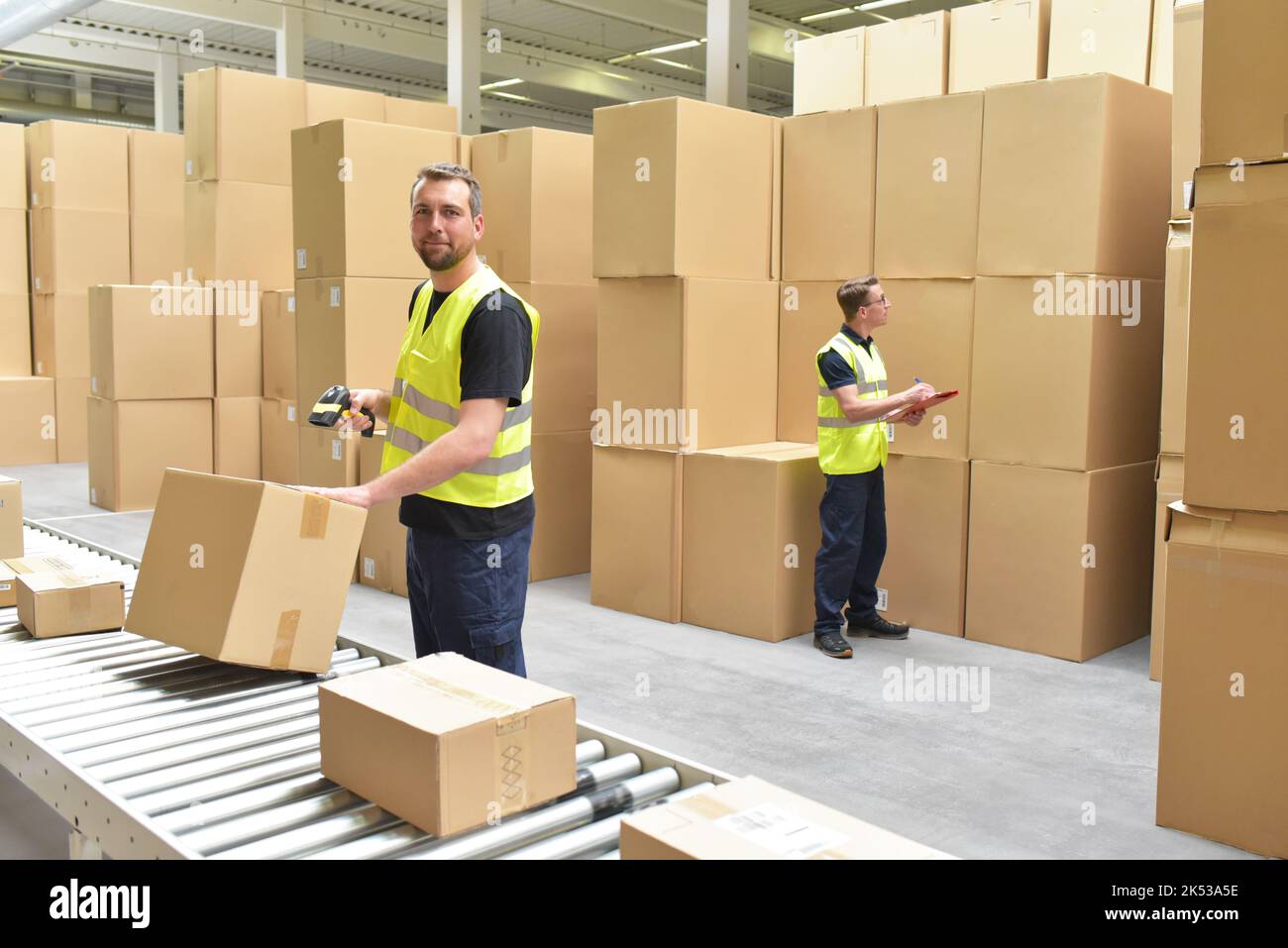 Arbeiter in einem Lager in der Logistik-Branche Verarbeitung von Paketen auf der Montagelinie - Transport und Verarbeitung von Aufträgen im Handel Stockfoto