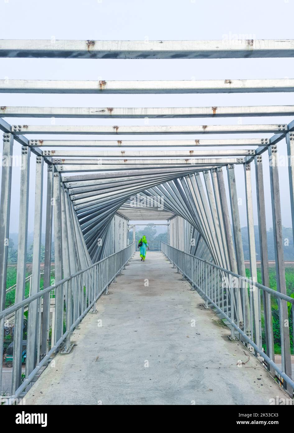 Glückliche Frau Tourist zu Fuß und bewundern Sie die einzigartige Innenausstattung der über die Brücke. Frauen auf der Fußgängerbrücke. Rückansicht. Stockfoto