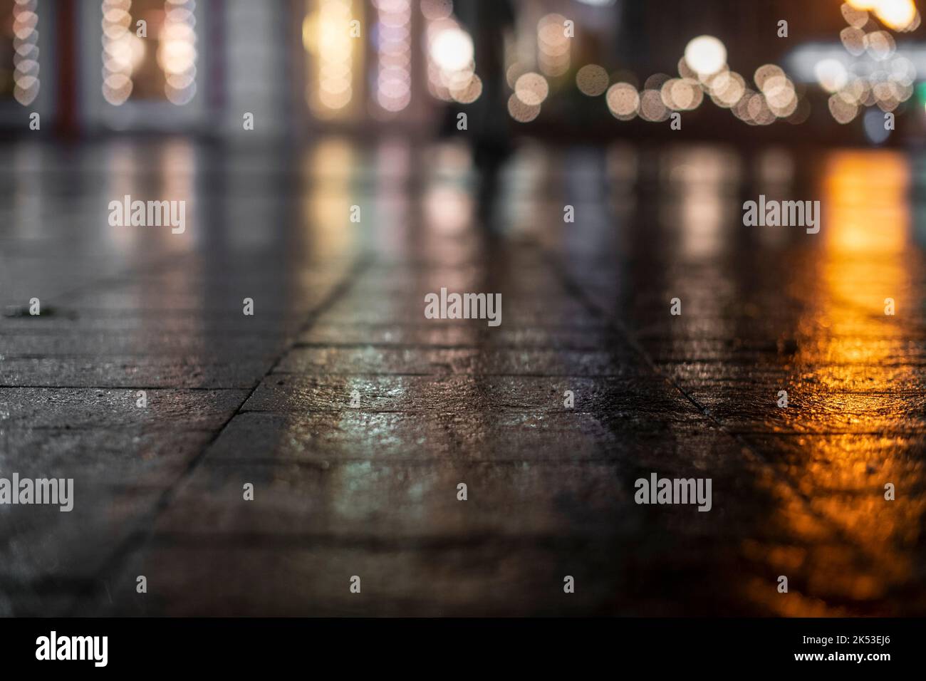 Nächtliche Stadtlandschaft, farbige Lichter spiegeln sich im Herbst im nassen Asphalt. Die Lichter einer regnerischen Nacht in der Herbststadt des Unschärfens und Bokeh. Neon Stockfoto