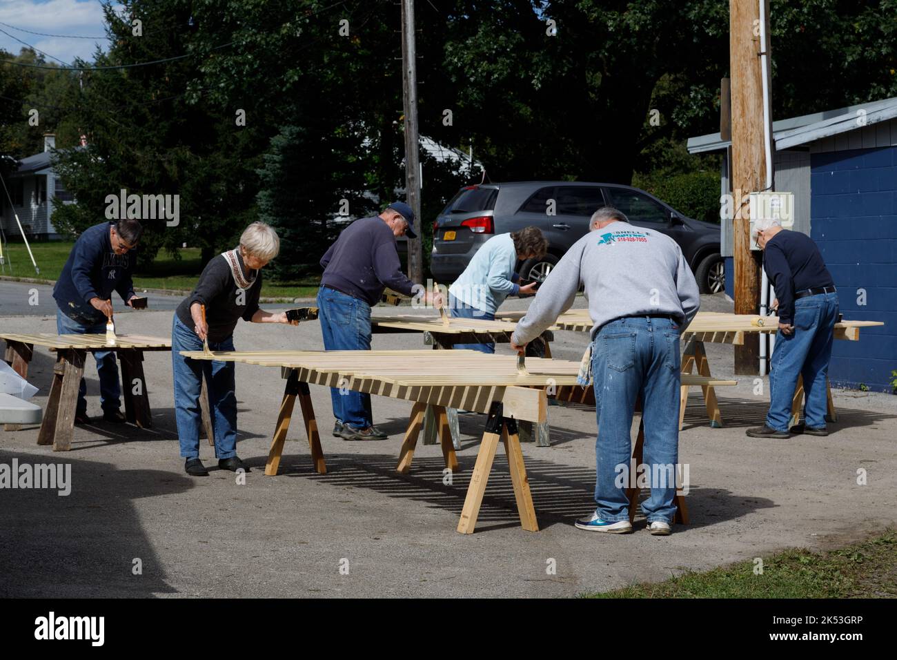 St. Johnsville, Montgomery County, New York: Freiwillige malen Holzlatten während der Reparatur der Tribüne auf dem Gemeinschaftsballfeld. Stockfoto