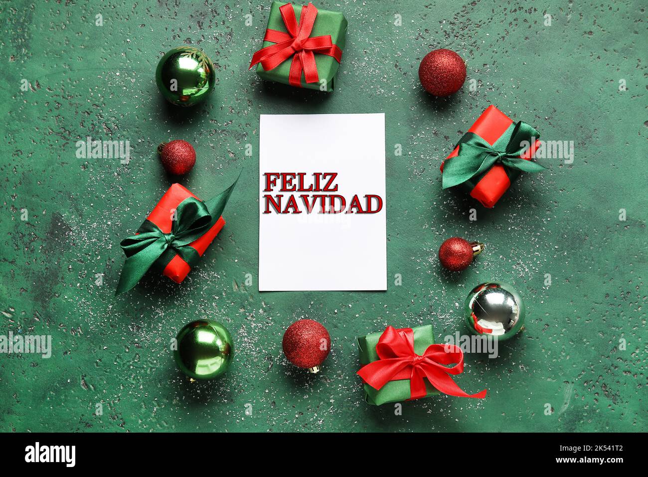 Karte mit Text FELIZ NAVIDAD (Spanisch für Frohe Weihnachten), Dekor und Geschenke auf grünem Hintergrund Stockfoto